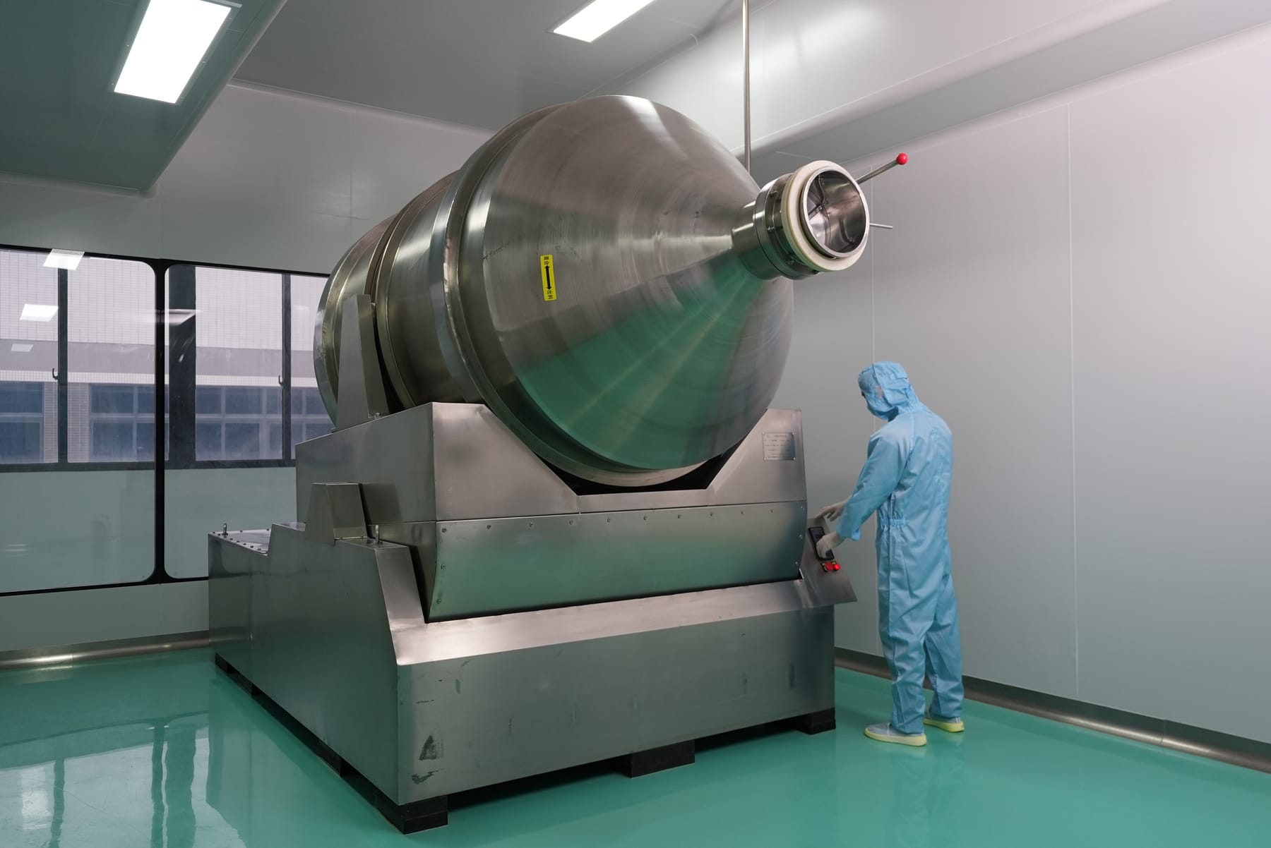 Double-cone blender operated by technician in GMP cleanroom